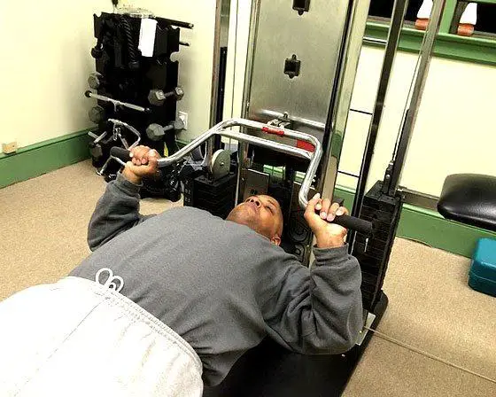 man using a bench press machine