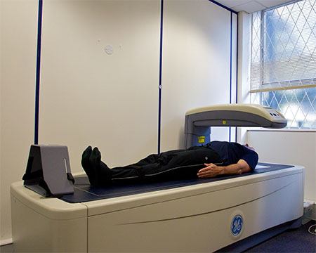 Man lying down on a DEXA body fat scanner