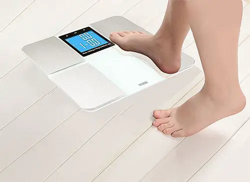 Woman stepping on the Insen digital body fat scale