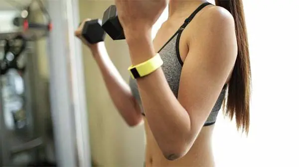 Woman holding a dumbell with blueweigh's activity tracker on her wrist